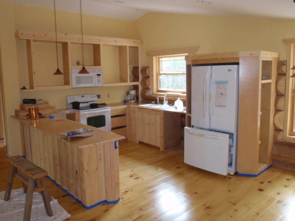 Kitchen with yellow walls and pine wood cabinetry before appliance upgrades