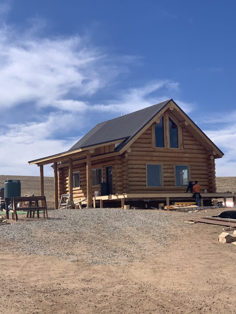 Custom log cabin with new wooden patio under construction