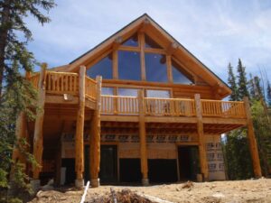 Chestnut wood cabin under construction with large vaulted windows