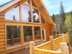 Log cabin with wooden deck overlooking forest