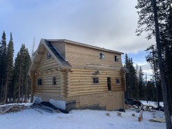 Large natural oak log cabin in snowy forest