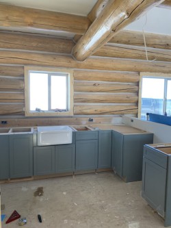 Custom kitchen with dusty blue cabinets and partially installed sink