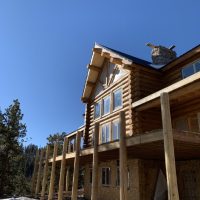 Wooden support beams for partially-completed wood deck of log cabin