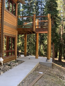 Mahogany wood cabin with wooden porch above concrete open space