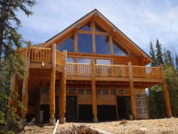 Chestnut wood cabin under construction with large vaulted windows