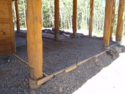 Large wooden support beams and cement flooring framework beneath deck