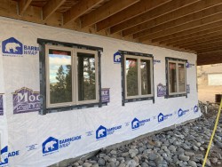 Partially built home with barricade wrap on exterior wall