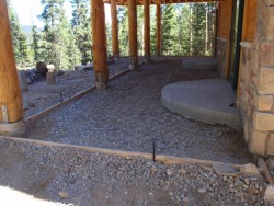 Open space below wooden deck of two-story cabin