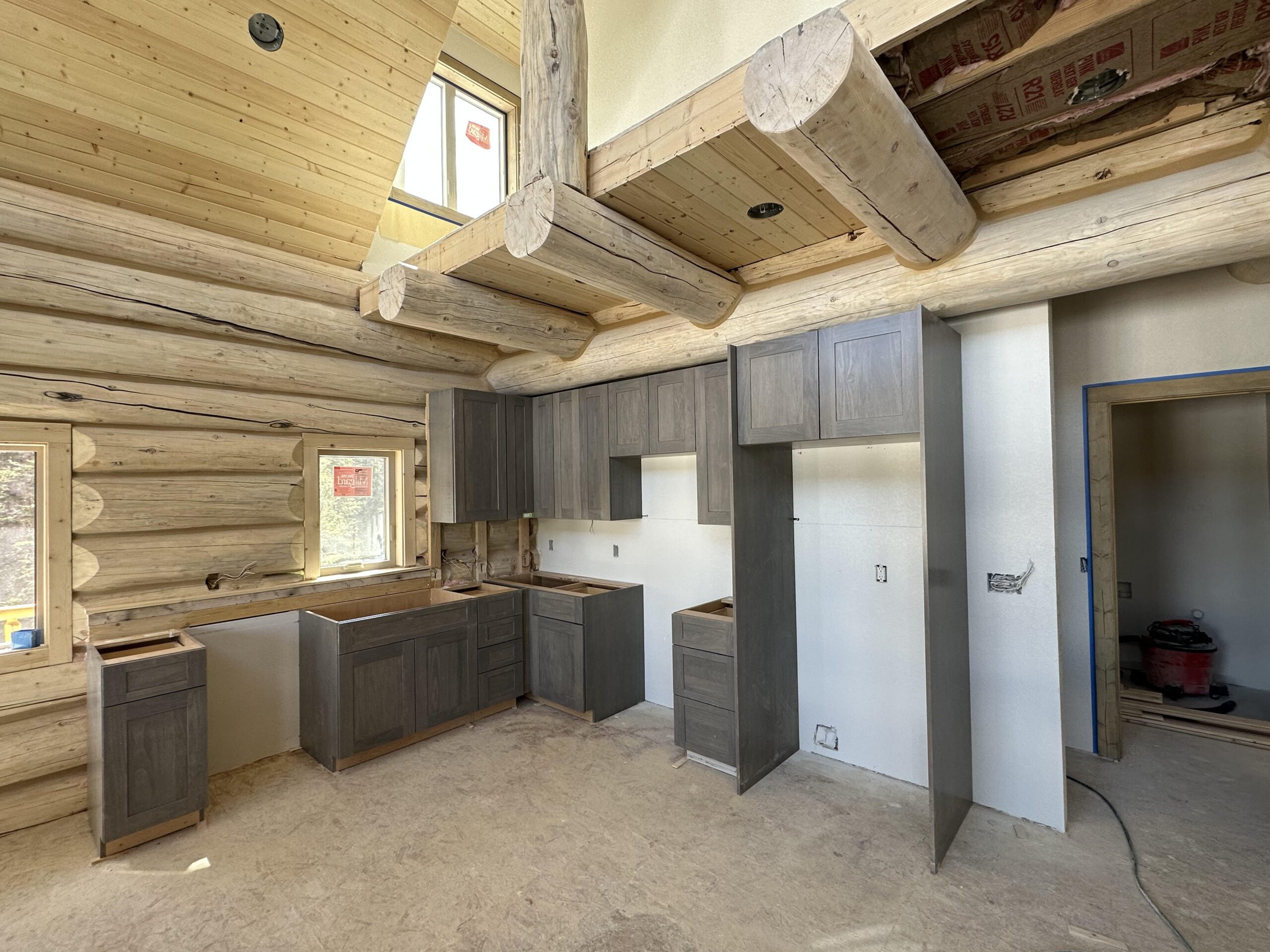 Kitchen remodel with pine overhead beams and gray wood cabinets